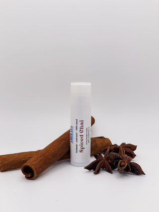 tube of lip balm with cinnamon and anise seeds in the background
